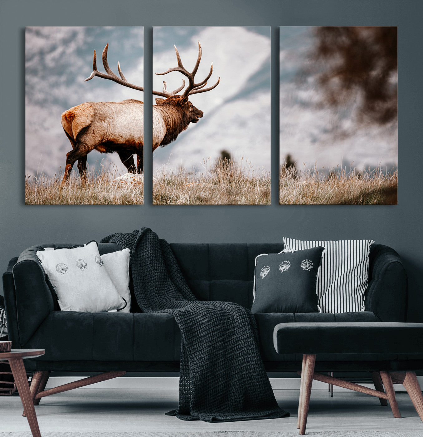 Majestic elk with large antlers standing in grass with snowy mountains in background, perfect for rustic cabin or lodge style decor.