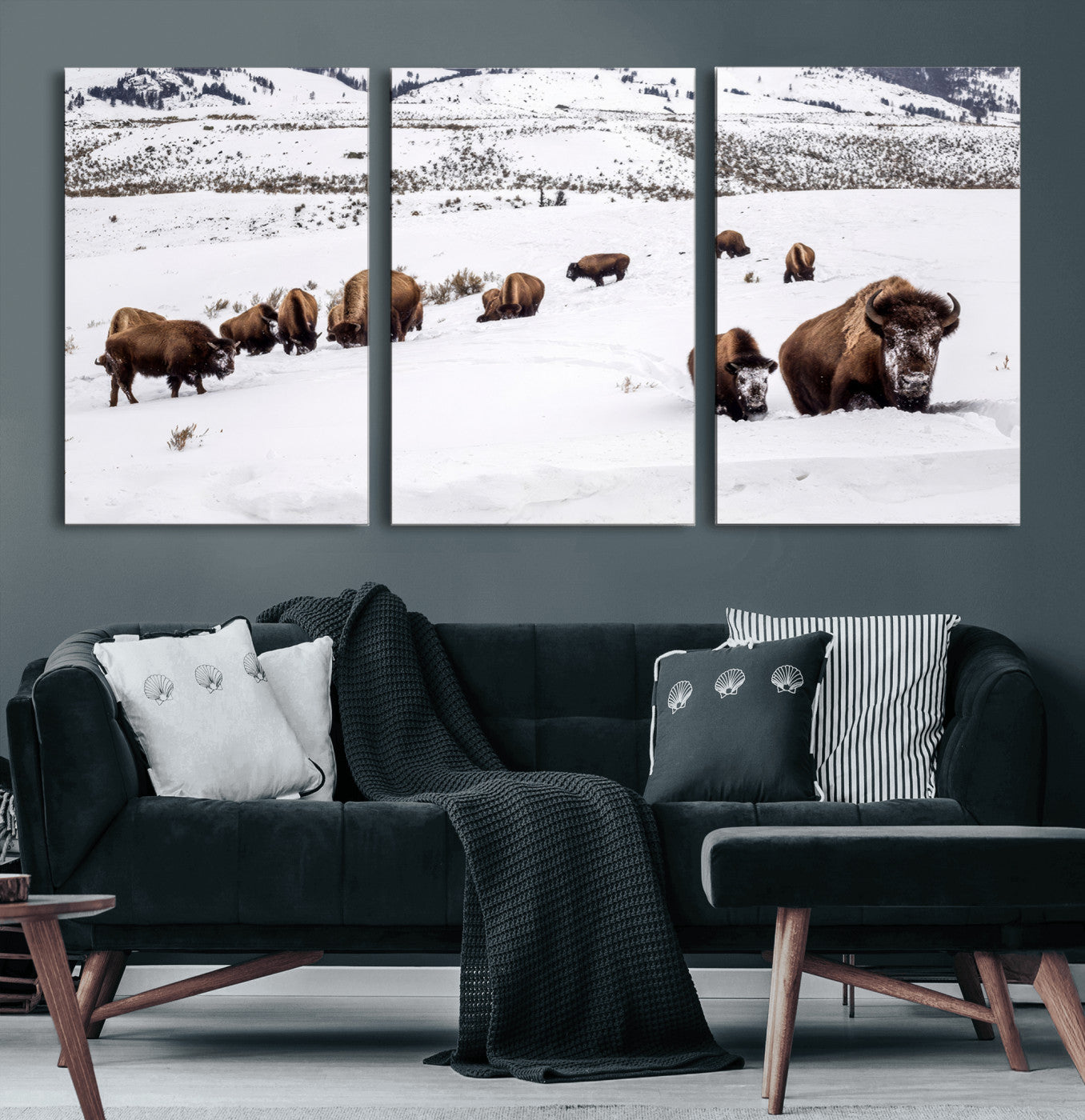 A herd of bison walking through deep snow in a mountain valley, perfect for rustic, cabin or western-themed wall decor.