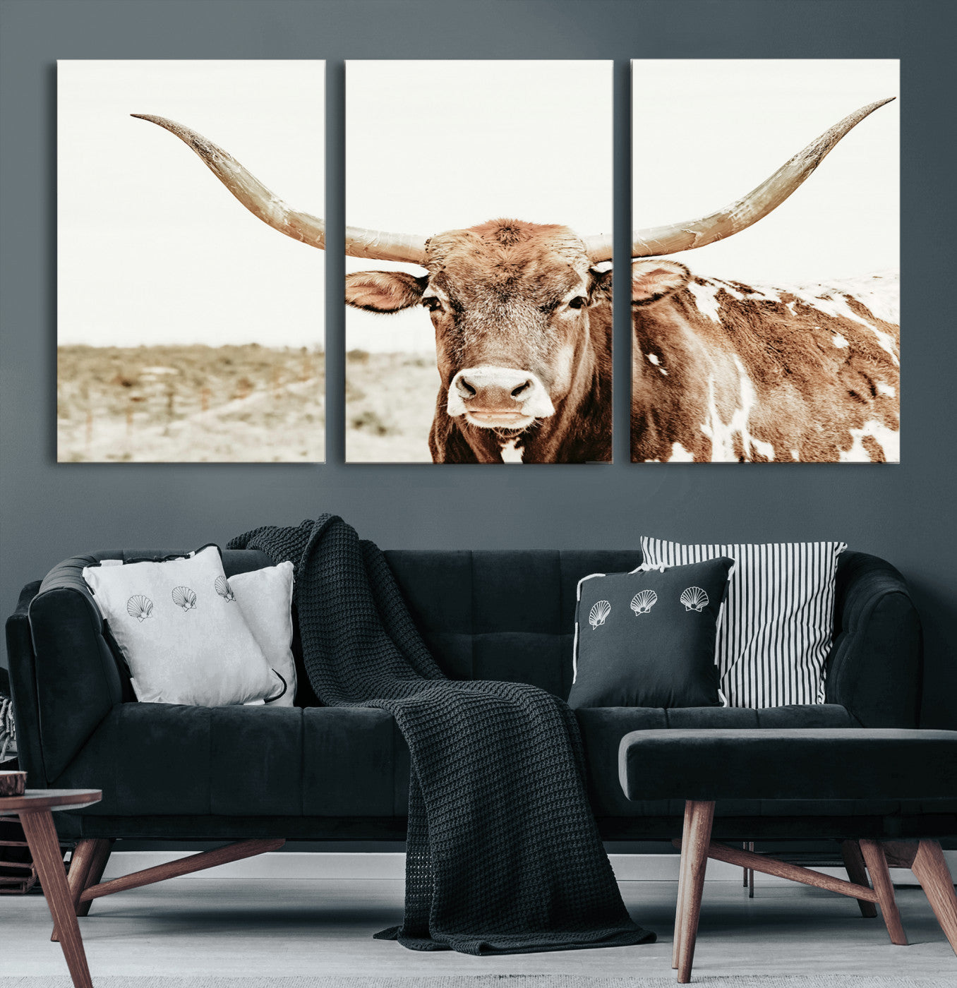 A Texas longhorn bull with wide horns, standing in a dry field under soft light, ideal for rustic farmhouse or western-themed interiors.