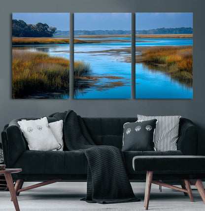 A peaceful marshland scene with calm blue water reflecting the surrounding grasses and trees, capturing the beauty of nature in a serene landscape.