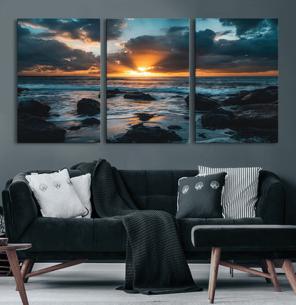 An awe-inspiring sunset over the ocean with rays of light piercing through dramatic clouds, creating a beautiful seascape with rocks in the foreground.