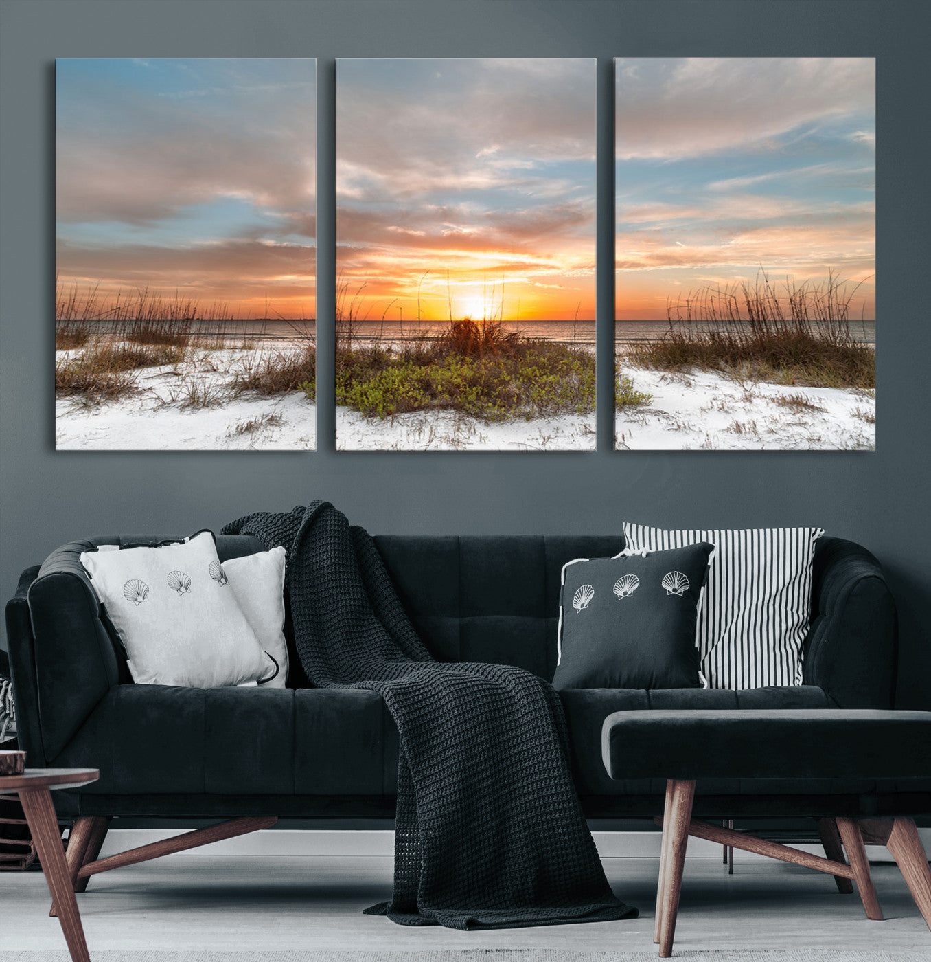 A tranquil beach scene featuring golden sunset hues over the water, with grasses in the foreground and a peaceful, serene atmosphere.