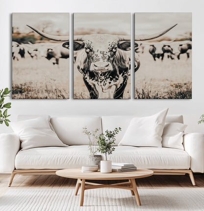 Canvas of a speckled Texas longhorn standing boldly in a field with a herd behind, perfect for rustic western or farmhouse wall decor.