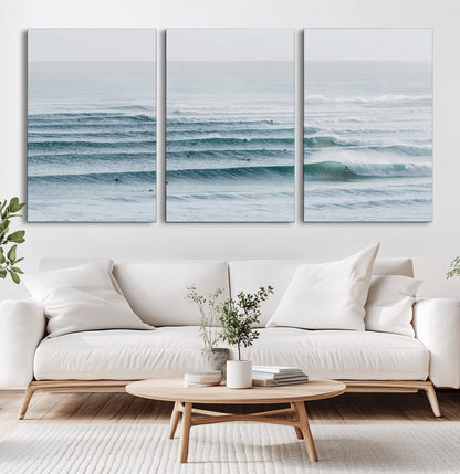 High-angle view of surfers lining up across layered ocean waves, ideal for minimal coastal or surf-inspired room decor.