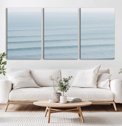 Framed canvas of repeating ocean waves with a distant solo surfer, ideal for minimalist ocean or calm coastal wall decor.
