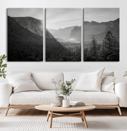 Black and white landscape of Yosemite with sun rays peeking over El Capitan, ideal for moody nature or modern rustic decor.