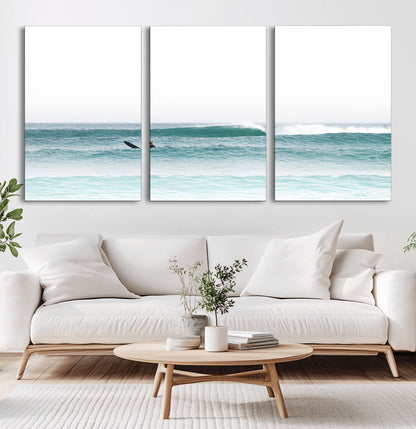 Minimalist photo of a lone surfer on calm aqua waves under bright sky, perfect for Scandinavian coastal or serene ocean-inspired home decor.