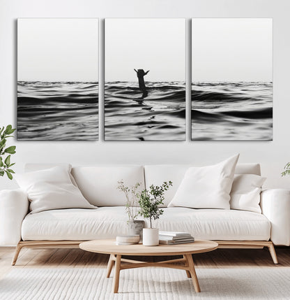Black and white ocean with a hand making a surfer sign among dark waves, creating a dramatic and minimalist seascape with bold contrast.