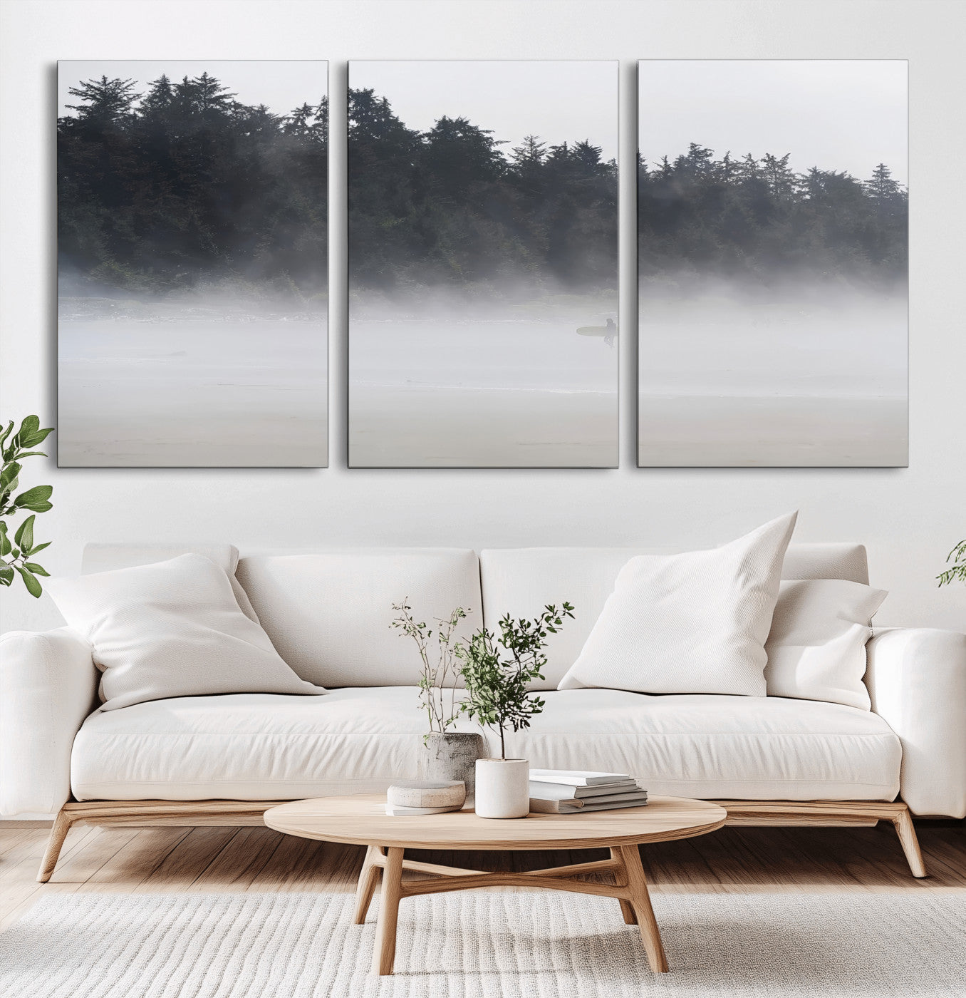 A lone surfer carrying a board through a misty shoreline, surrounded by dense trees and fog, creating a peaceful and mysterious coastal scene.