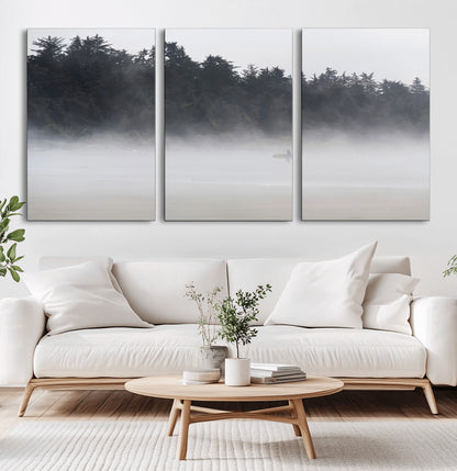 A lone surfer carrying a board through a misty shoreline, surrounded by dense trees and fog, creating a peaceful and mysterious coastal scene.
