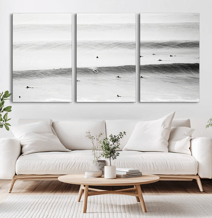 A monochrome photograph of swimmers gliding through gentle ocean waves, evoking a sense of calm and movement.
