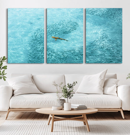 Aerial view of a shark swimming through a swirl of fish in clear turquoise waters, perfect for calm coastal or beach house decor.