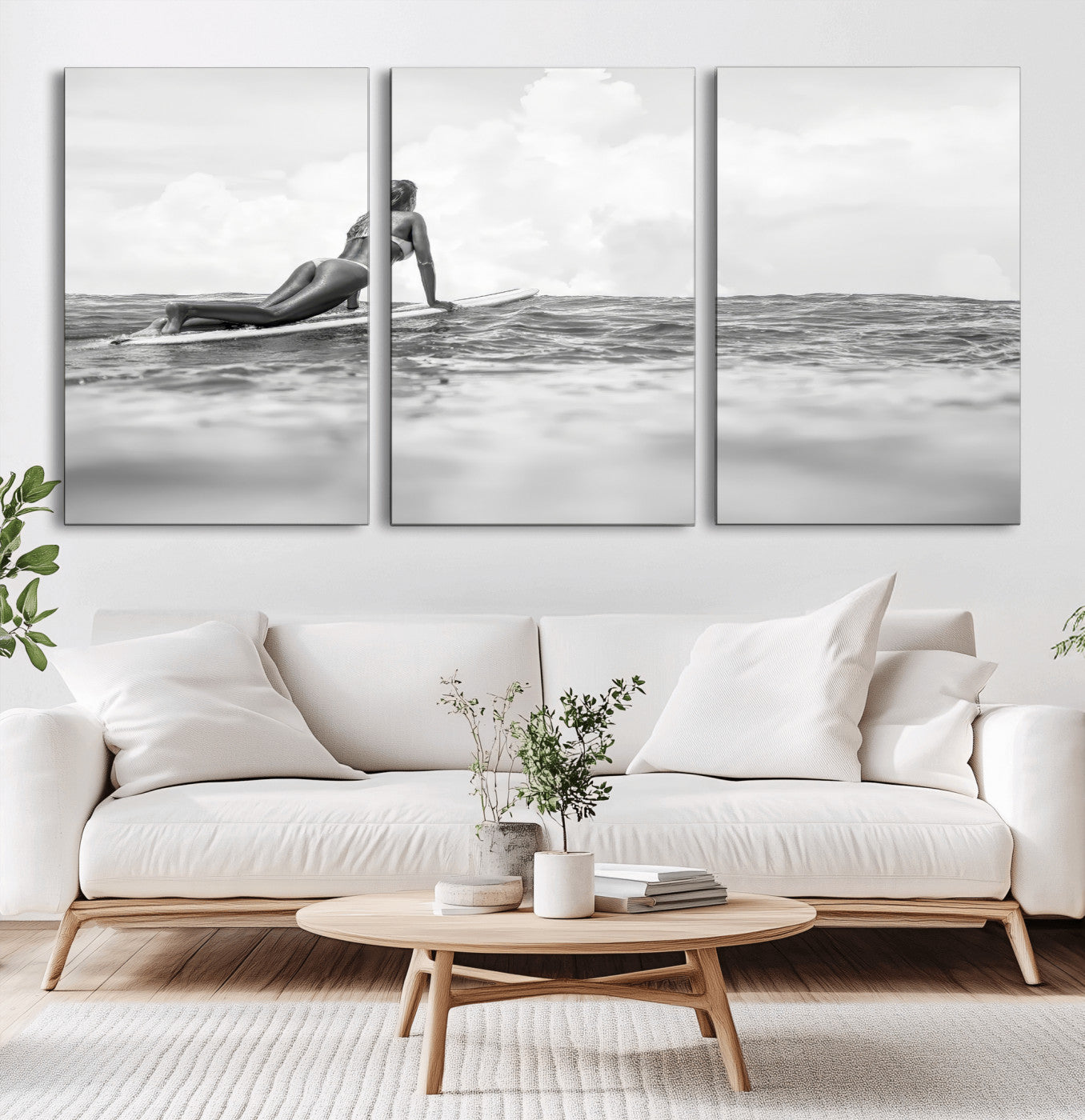 A black and white ocean scene featuring a surfer girl waiting on her board, gazing at the horizon, capturing a tranquil and adventurous coastal moment.
