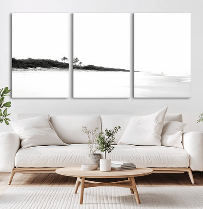 A black and white minimalist coastal scene with a vast open beach, distant palm trees, and a lone figure walking along the shoreline, evoking serenity and solitude.