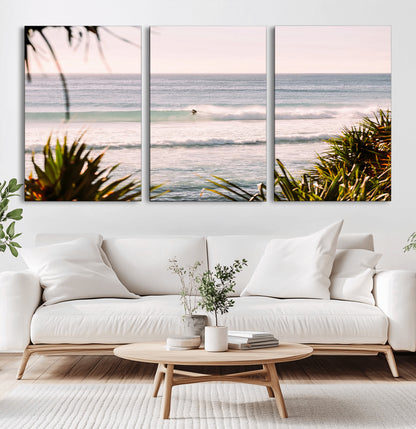 Canvas of a lone surfer riding a pastel wave at sunrise, perfect for tropical or coastal-themed spaces with a relaxed, airy vibe.