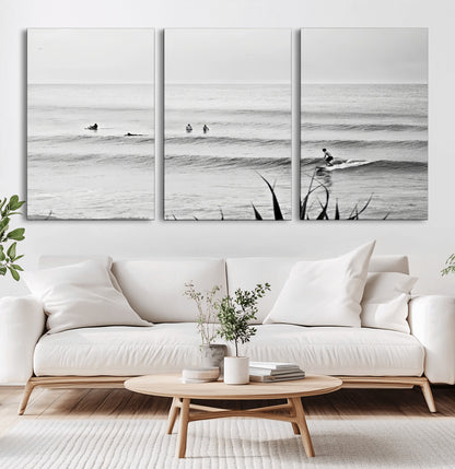 Monochrome canvas of surfers on calm ocean waves, ideal for minimalist coastal or beach-inspired interior decor.