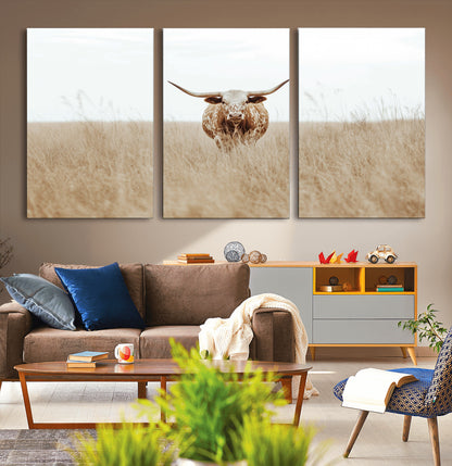 Texas Longhorn bull standing alone in dry grass with neutral tones, ideal for rustic western or cowboy-themed wall decor.
