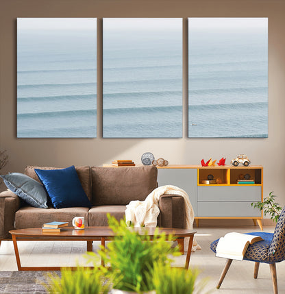 Framed canvas of repeating ocean waves with a distant solo surfer, ideal for minimalist ocean or calm coastal wall decor.