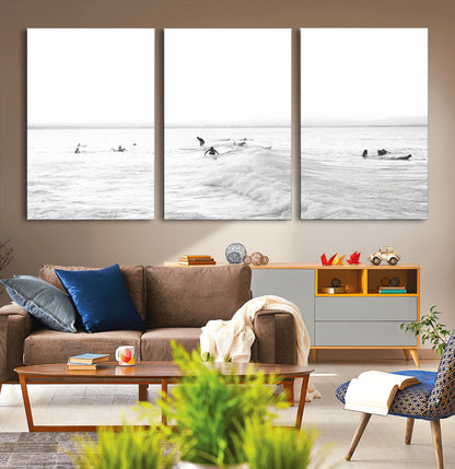 Monochrome photo of surfers riding and waiting on ocean waves, ideal for surf-themed or coastal energy wall decor.