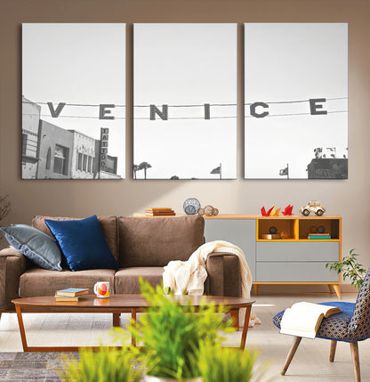 Black and white photo of Venice Beach sign and palm-lined street, perfect for urban coastal or minimalist LA-inspired wall decoration.