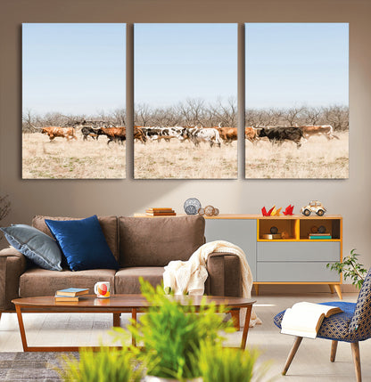 Framed wall art of Texas longhorn cattle walking through a dry, neutral-toned prairie, perfect for rustic farmhouse or western-themed home decor.
