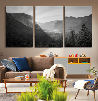 Black and white landscape of Yosemite with sun rays peeking over El Capitan, ideal for moody nature or modern rustic decor.