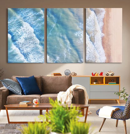 Aerial photo of soft blue waves meeting sandy shore, perfect for modern coastal or beach-themed decor with a light and tranquil aesthetic.