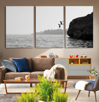Black and white canvas of two figures cliff jumping into the sea, captured with moody tones, ideal for modern coastal or adventure-themed home decor.   2/2