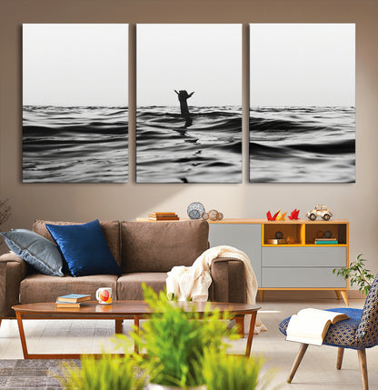Black and white ocean with a hand making a surfer sign among dark waves, creating a dramatic and minimalist seascape with bold contrast.
