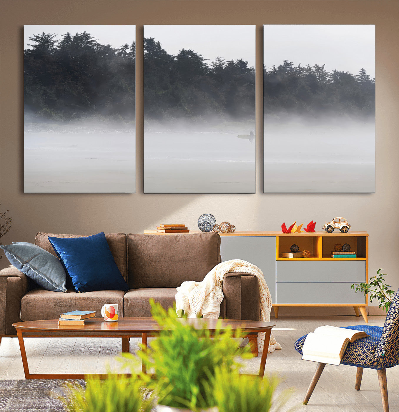 A lone surfer carrying a board through a misty shoreline, surrounded by dense trees and fog, creating a peaceful and mysterious coastal scene.