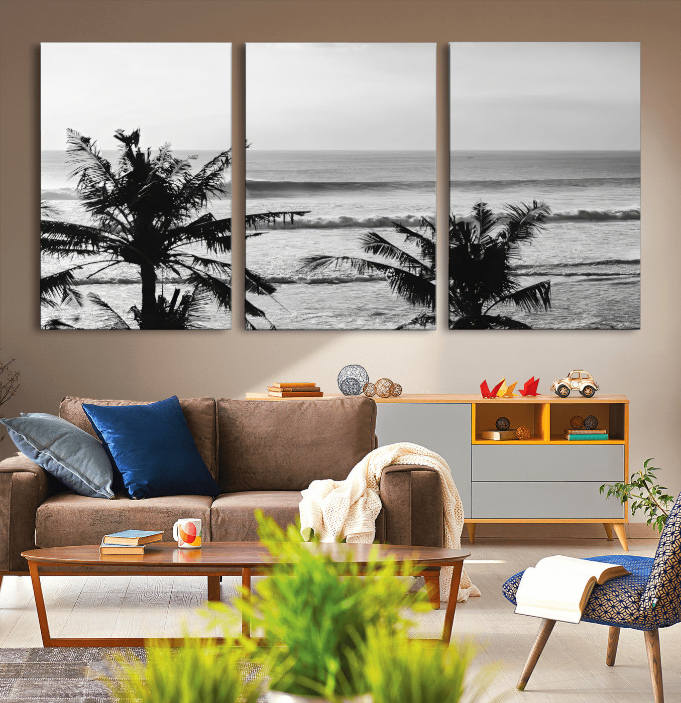 Black and white view of ocean waves crashing on a tropical coastline, framed by silhouetted palm trees under a vast, open sky.
