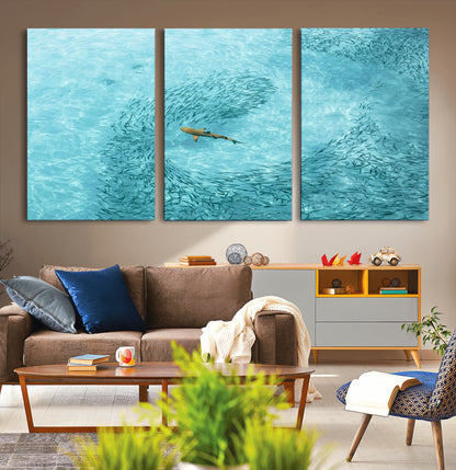 Aerial view of a shark swimming through a swirl of fish in clear turquoise waters, perfect for calm coastal or beach house decor.