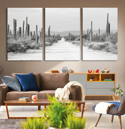 A black and white desert road stretching through a cactus-filled landscape, creating a rugged and timeless southwestern aesthetic with a sense of adventure.