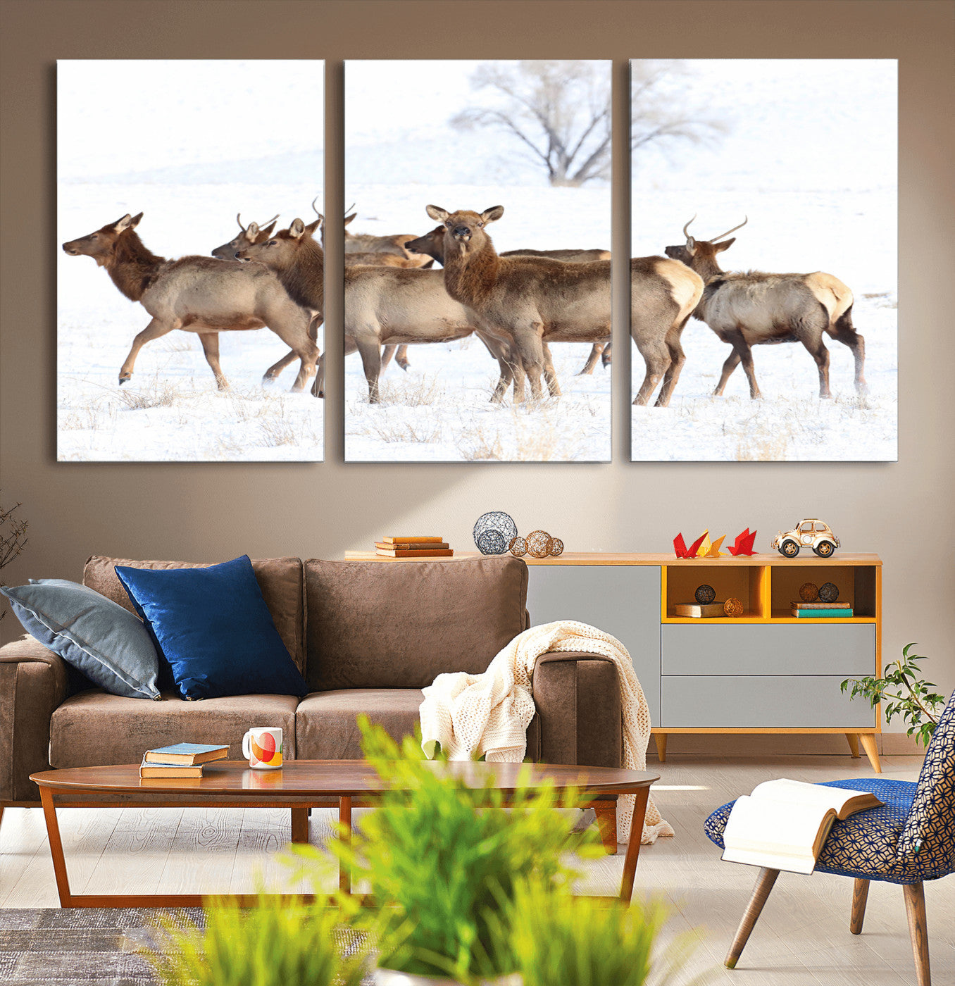 A group of elk standing on snowy terrain with a tree in the background, perfect for rustic or lodge-style winter wall decor.