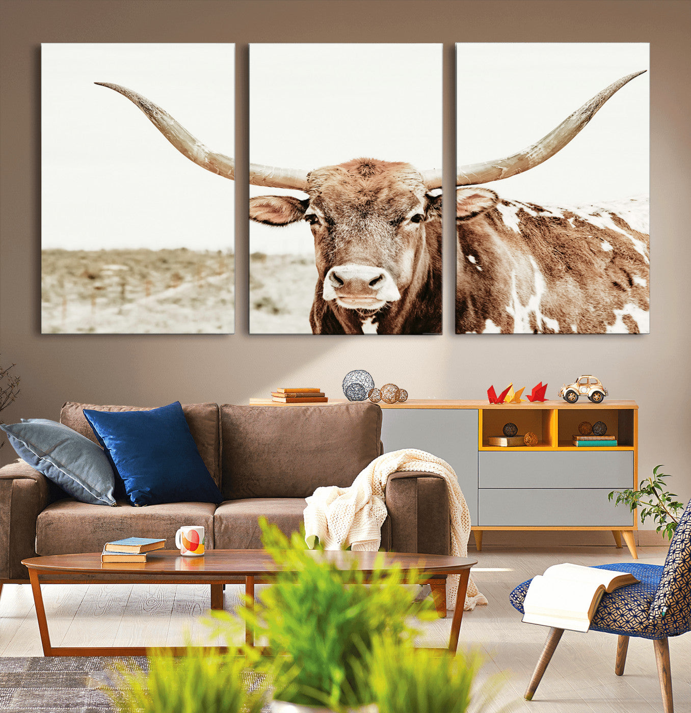 A Texas longhorn bull with wide horns, standing in a dry field under soft light, ideal for rustic farmhouse or western-themed interiors.