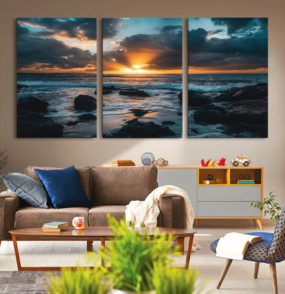 An awe-inspiring sunset over the ocean with rays of light piercing through dramatic clouds, creating a beautiful seascape with rocks in the foreground.