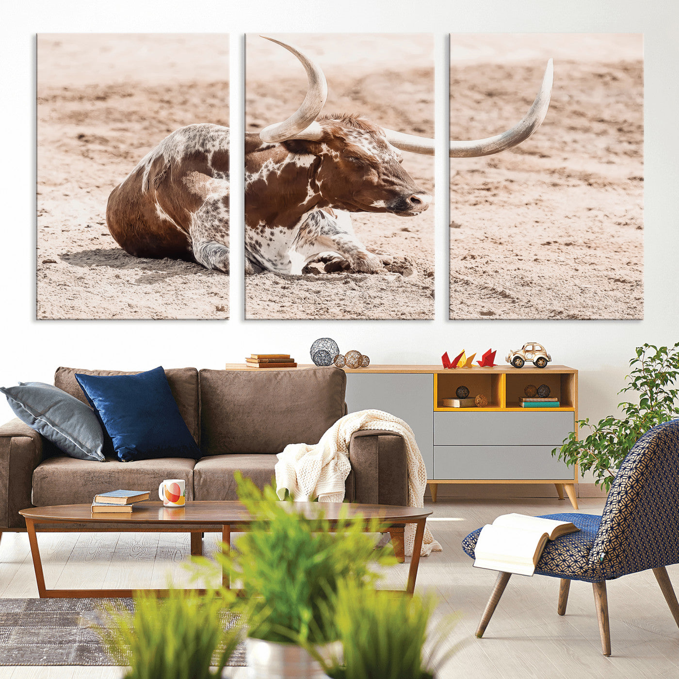 Texas Longhorn bull resting on dusty ground with warm tones, ideal for rustic western or farmhouse-themed wall decor.
