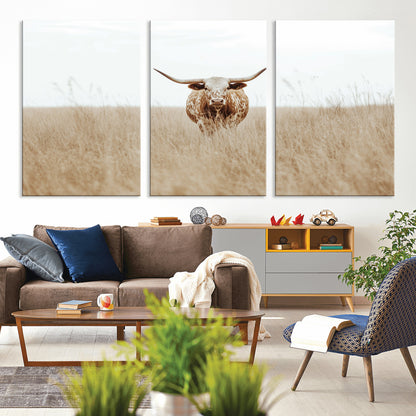 Texas Longhorn bull standing alone in dry grass with neutral tones, ideal for rustic western or cowboy-themed wall decor.