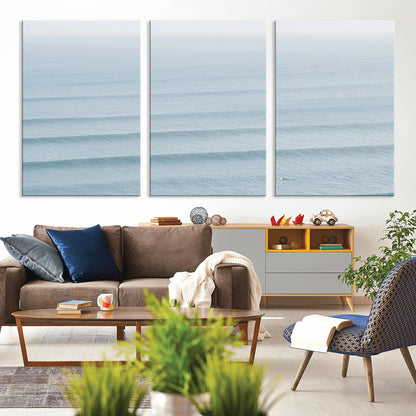 Framed canvas of repeating ocean waves with a distant solo surfer, ideal for minimalist ocean or calm coastal wall decor.