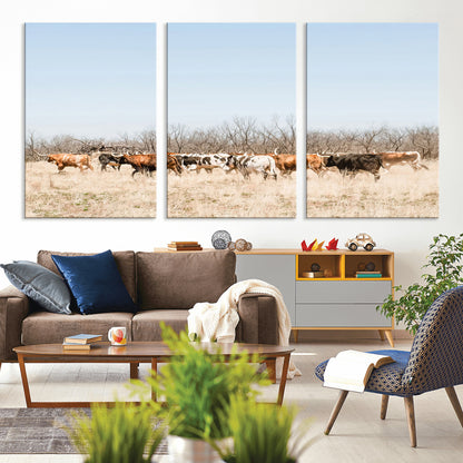Framed wall art of Texas longhorn cattle walking through a dry, neutral-toned prairie, perfect for rustic farmhouse or western-themed home decor.
