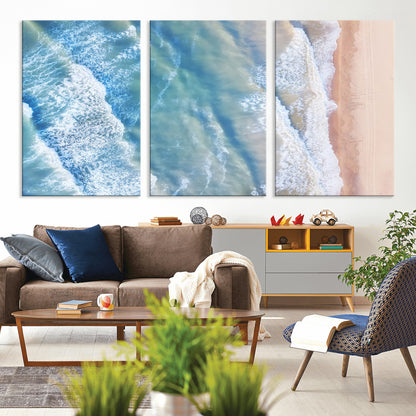 Aerial photo of soft blue waves meeting sandy shore, perfect for modern coastal or beach-themed decor with a light and tranquil aesthetic.