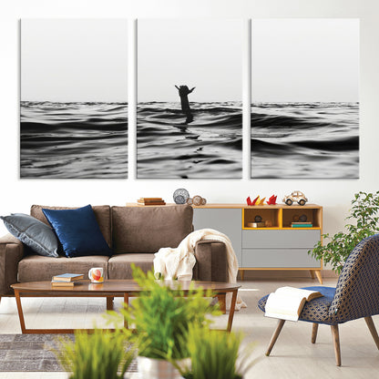 Black and white ocean with a hand making a surfer sign among dark waves, creating a dramatic and minimalist seascape with bold contrast.