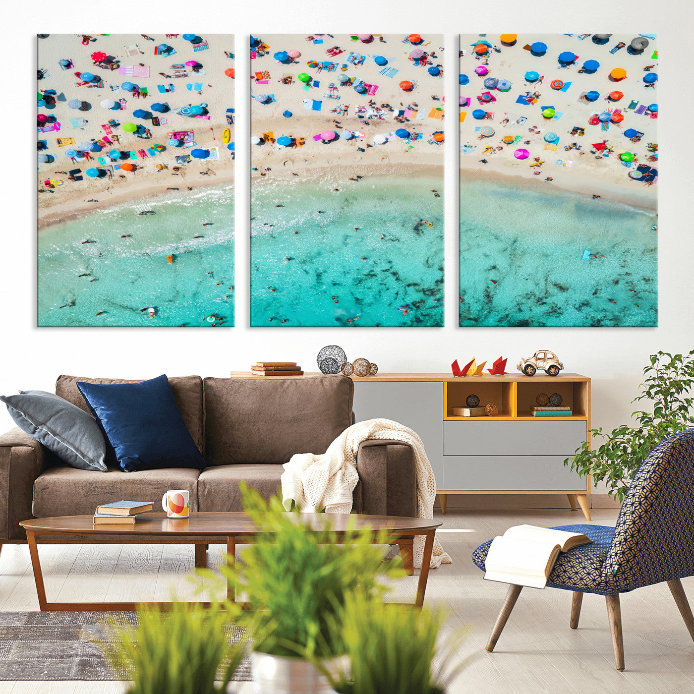 Aerial view of a vibrant beach filled with colorful umbrellas and people enjoying the turquoise ocean, capturing a lively summer vacation scene.