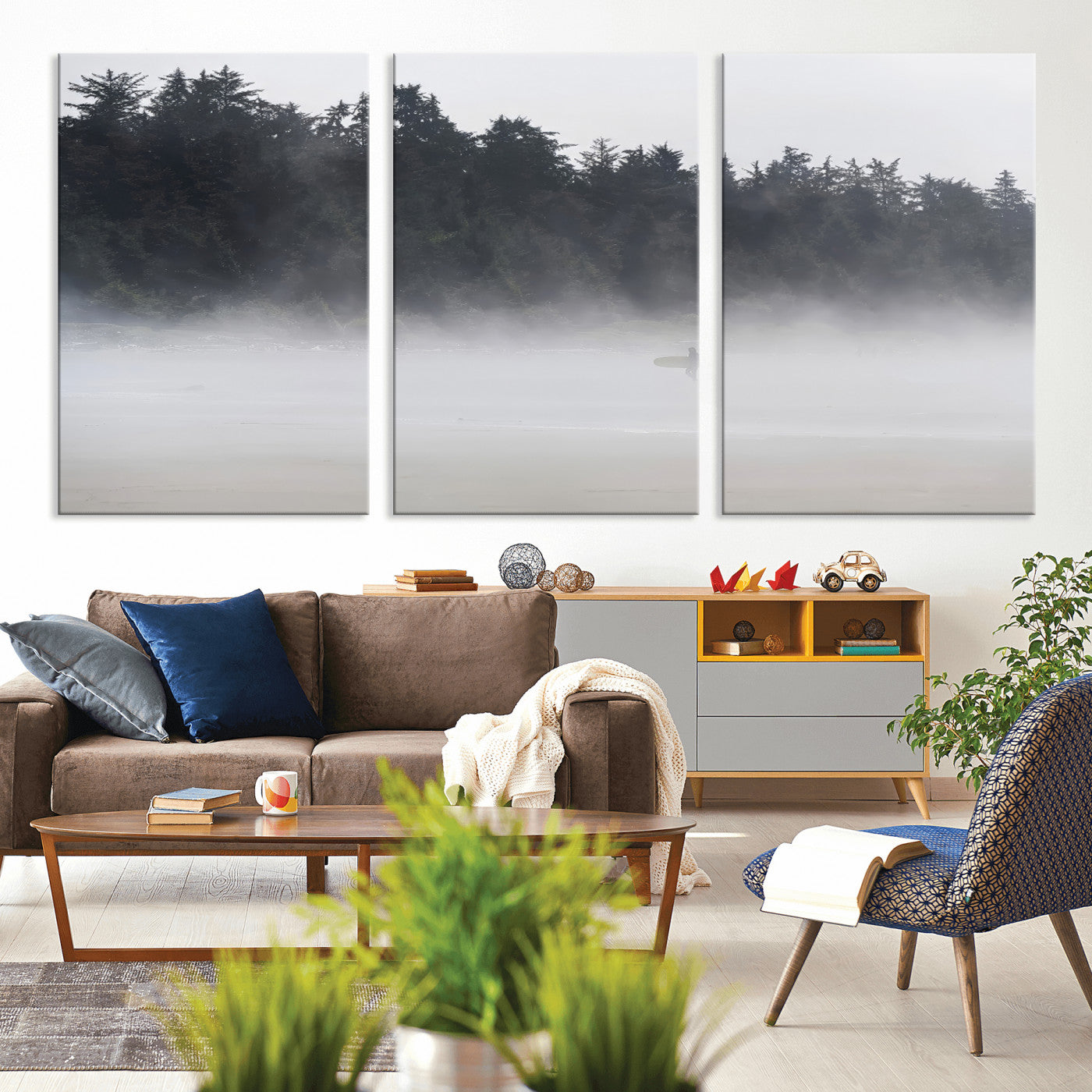 A lone surfer carrying a board through a misty shoreline, surrounded by dense trees and fog, creating a peaceful and mysterious coastal scene.