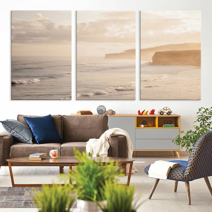 Golden hour seascape with misty cliffs and gentle waves rolling towards the shore, capturing a tranquil and warm coastal atmosphere.