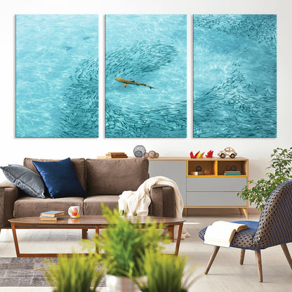 Aerial view of a shark swimming through a swirl of fish in clear turquoise waters, perfect for calm coastal or beach house decor.