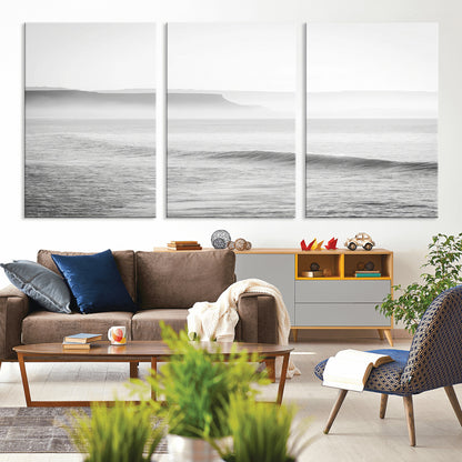 A black and white minimalist seascape featuring soft rolling waves and misty distant cliffs, creating a serene and timeless coastal atmosphere.