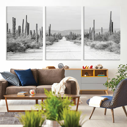 A black and white desert road stretching through a cactus-filled landscape, creating a rugged and timeless southwestern aesthetic with a sense of adventure.