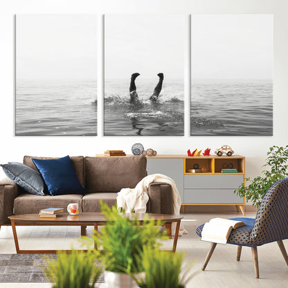 A black and white minimalist water scene capturing a playful splash as a swimmer dives upside down, creating a carefree and artistic aquatic aesthetic.