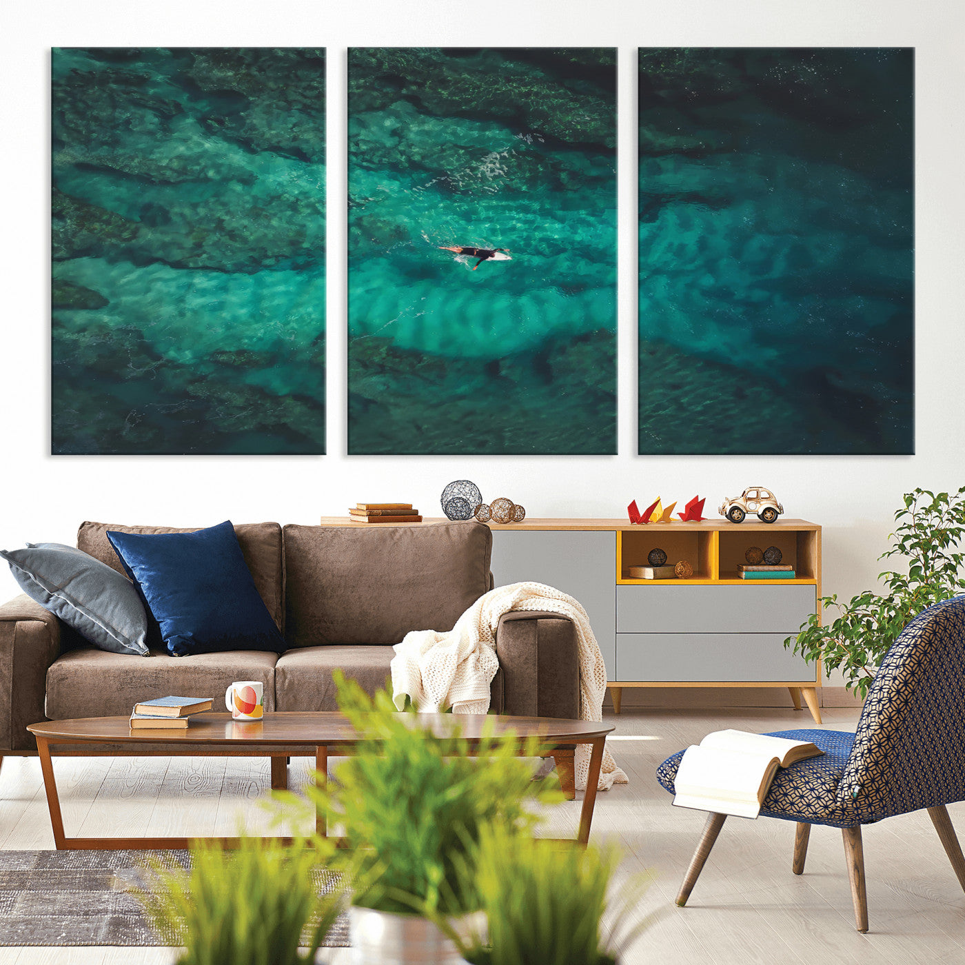 An aerial view of a solo surfer paddling through crystal-clear turquoise waters over a sunlit reef, capturing the beauty and serenity of open water surfing.